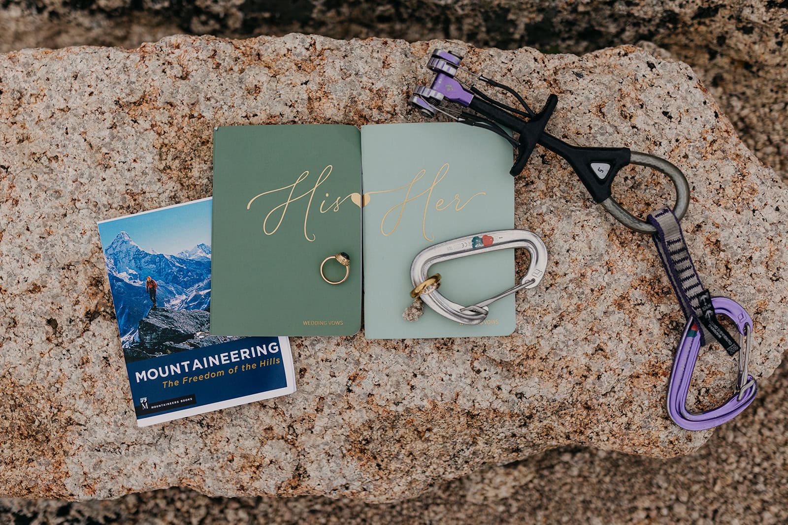 A detail image of wedding rings, vow books and climbing equipment