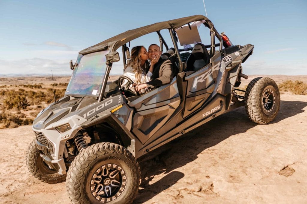 A couple off roads in Moab on a sunny day.