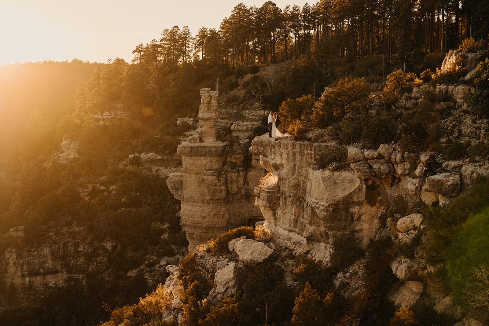A couple on the edge of an overlook at sunset in Flagstaff.