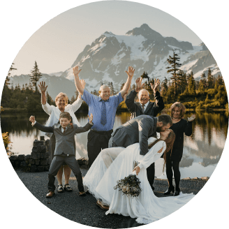 A person dipping their partner and kissing them on their wedding day with guests cheering in the background