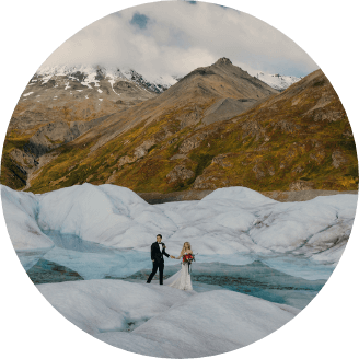 A couple holding hands and walking along small icy hills 