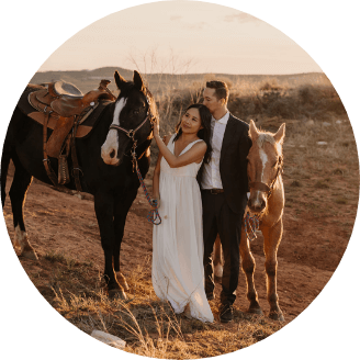 A couple poses with two horses on their elopement day.